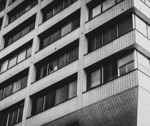 a black and white image of an office building in a city