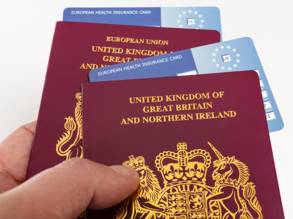 UK passports displayed with European Health Insurance Cards showing travel healthcare documentation for British travellers